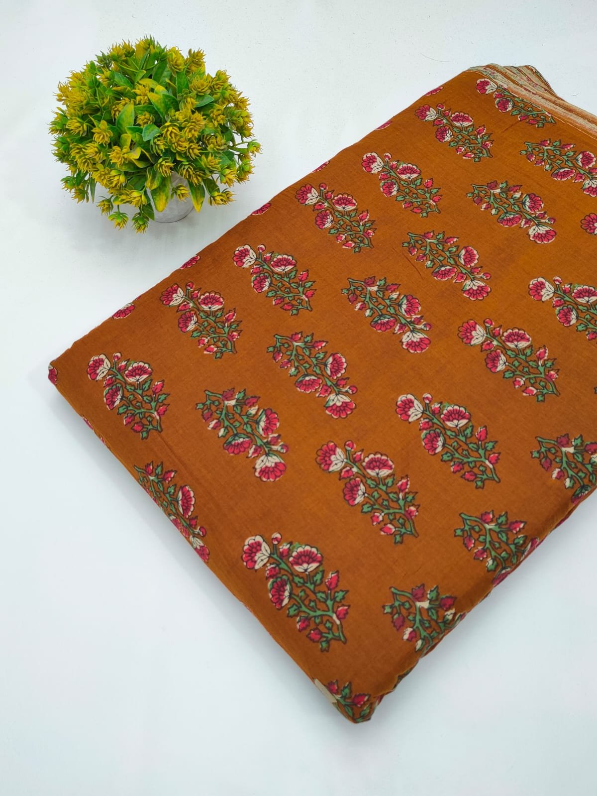 Orange fabric with green-red ethnic motif design